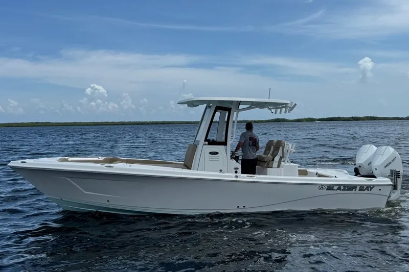 The Image of 2027 Blazer Bay Makaira 2800 boat cruising on open water under a clear sky. - 16