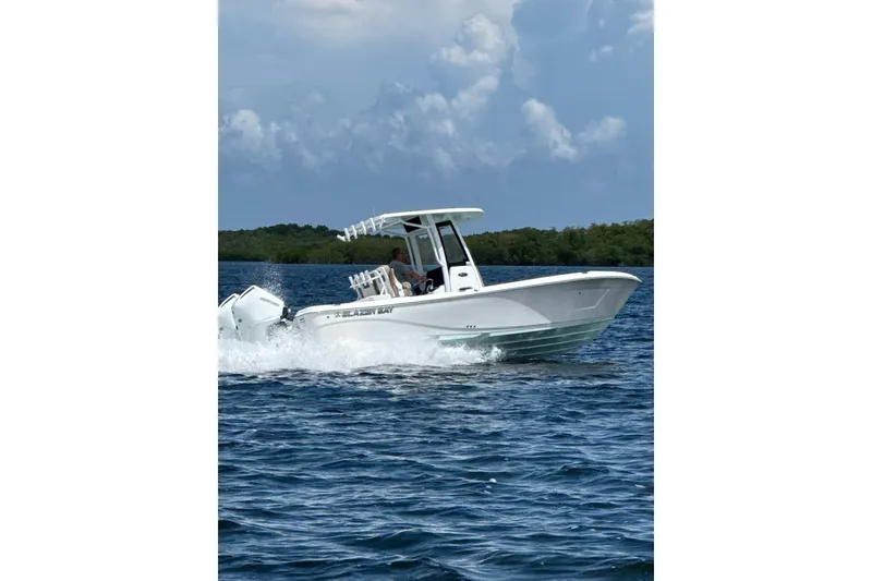 Slide: The Image of 2027 Blazer Bay Makaira 2800 boat cruising on open water under a cloudy sky. - 17
