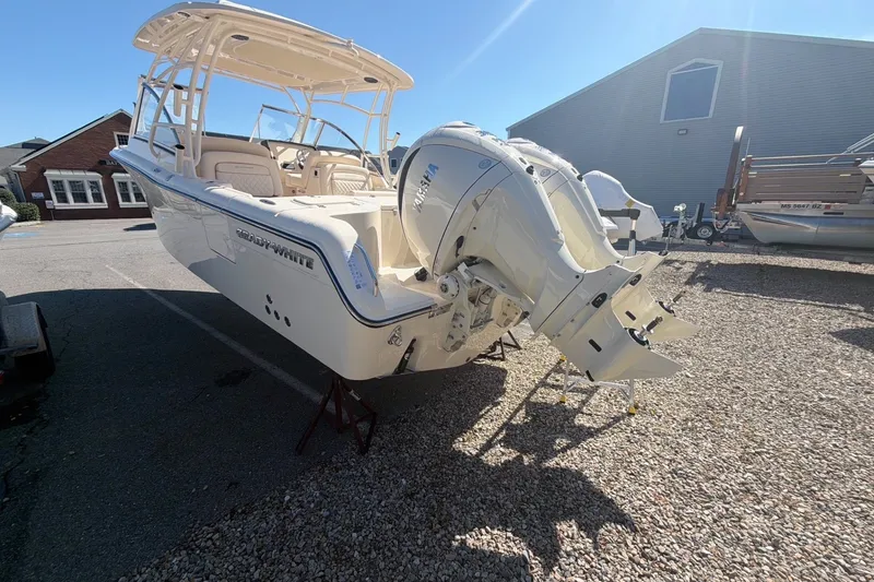 Slide: The Image of 2027 Grady-White Freedom 285 boat with dual outboard engines in a sunny marina. - 3