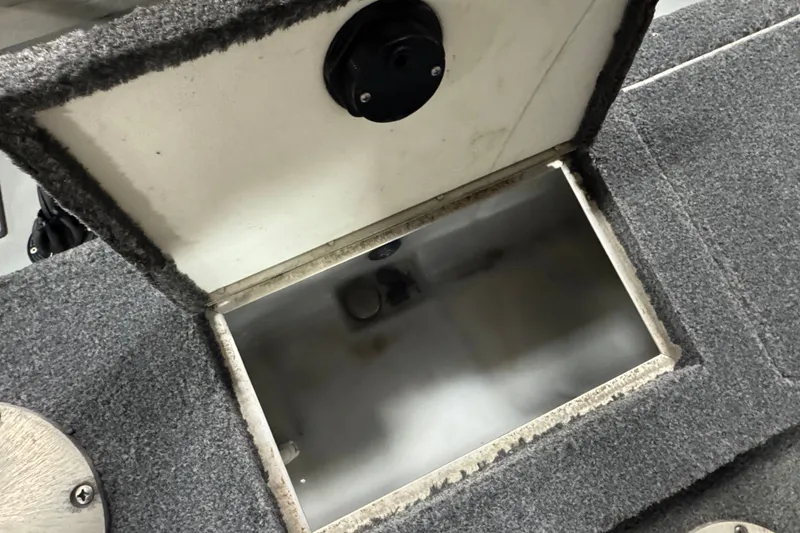 Slide: The Image of Open storage compartment in 2004 Lund 1775 Pro-V SE boat, featuring carpeted interior. - 9