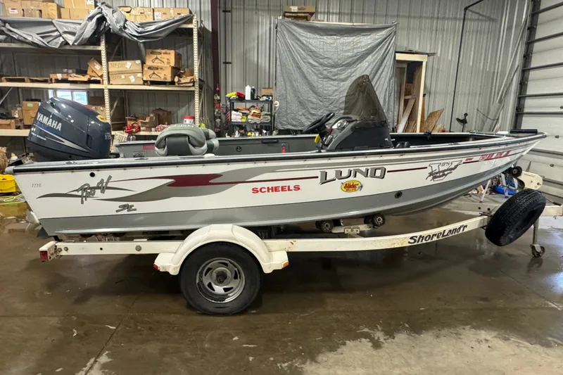 The Image of 2004 Lund 1775 Pro-V SE fishing boat on trailer in a storage facility. - 0