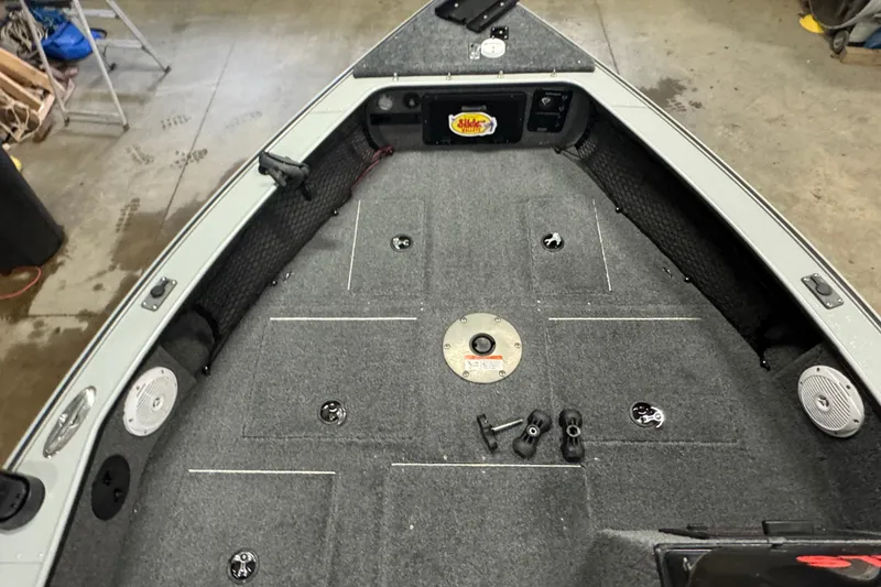 Slide: The Image of 2004 Lund 1775 Pro-V SE boat interior with carpeted deck and fishing rod holders. - 11