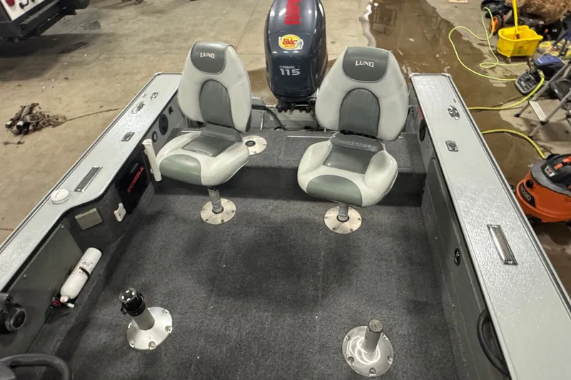 Slide: The Image of 2004 Lund 1775 Pro-V SE boat interior with two seats and a 115 HP motor. - 13