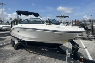 Slide: The Image of 2017 Sea Ray SPX 210 Outboard boat on trailer, parked outdoors under blue sky. - 2