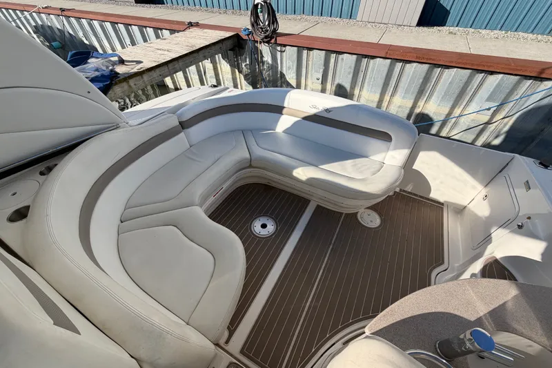 Slide: The Image of 2003 Sea Ray Sundancer 320 boat interior with white seating and wood-style flooring. - 11