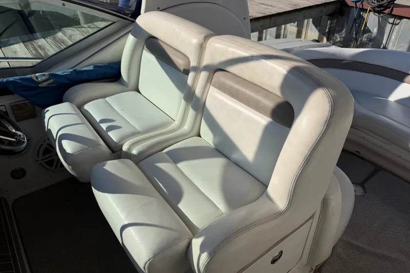 Slide: The Image of 2003 Sea Ray Sundancer 320 boat interior with white leather seats and steering area. - 15