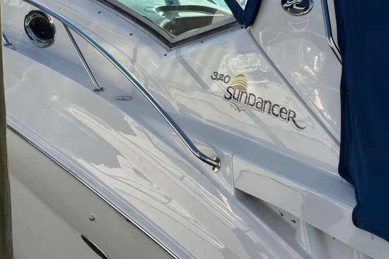 Slide: The Image of 2003 Sea Ray Sundancer 320 boat with sleek white exterior and blue cover. - 21