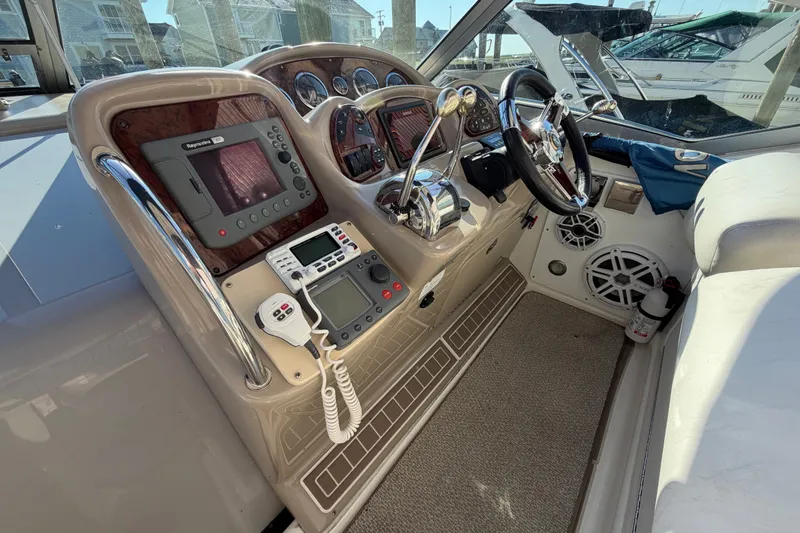 Slide: The Image of 2003 Sea Ray Sundancer 320 cockpit with navigation equipment and steering wheel. - 13