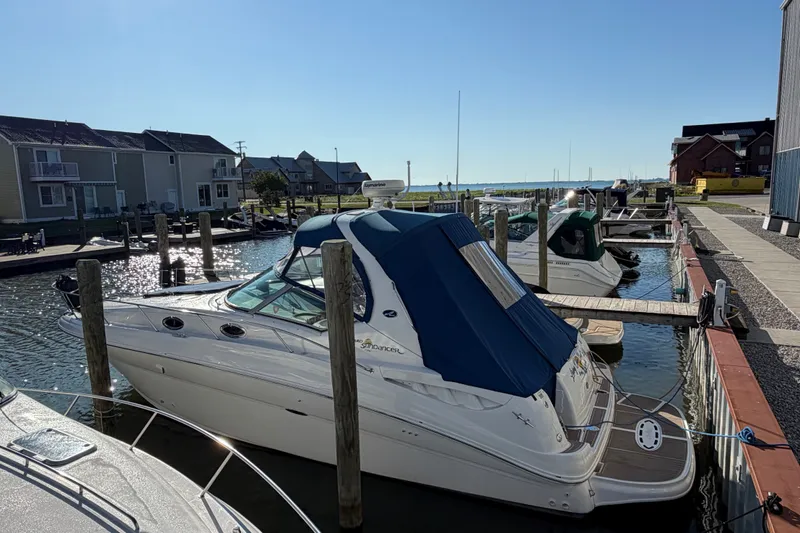 Slide: The Image of 2003 Sea Ray Sundancer 320 docked at a marina, featuring a blue canopy. - 6