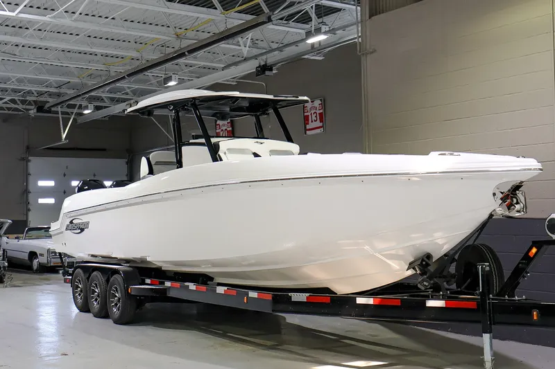 The Image of 2022 Sunsation 32 CCX boat on trailer in indoor showroom. - 1