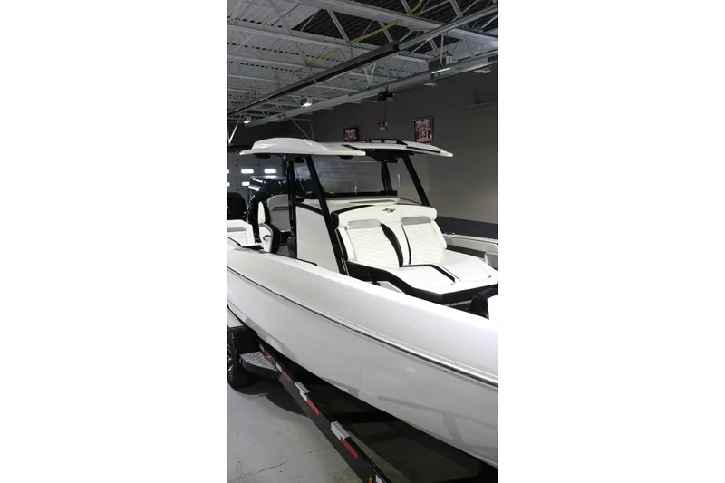 Slide: The Image of 2022 Sunsation 32 CCX boat with sleek white design in indoor showroom. - 2