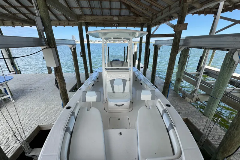 Slide: The Image of 2025 Robalo 226 Cayman boat docked under a wooden shelter by the water. - 17