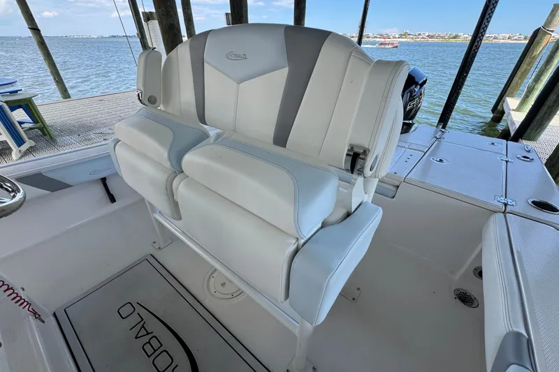Slide: The Image of 2025 Robalo 226 Cayman boat interior with white seating, docked by the water. - 21