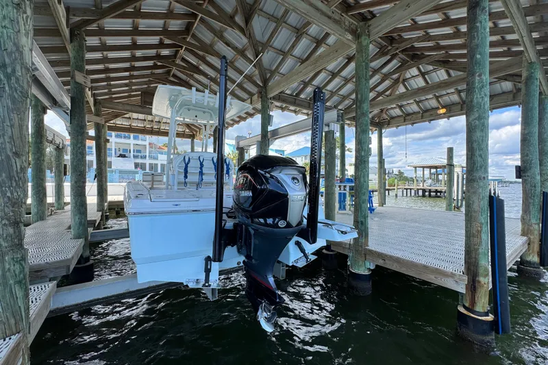 Slide: The Image of 2025 Robalo 226 Cayman boat docked under a wooden shelter with Yamaha outboard motor. - 9