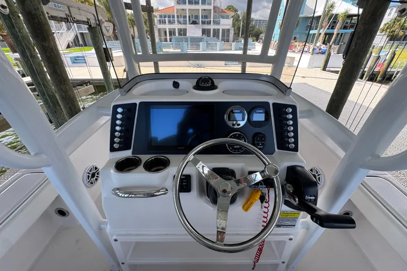 Slide: The Image of 2025 Robalo 226 Cayman boat dashboard with steering wheel and navigation controls. - 26