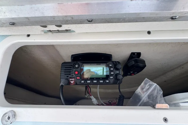Slide: The Image of VHF radio installed in a 2025 Robalo 226 Cayman boat compartment. - 28