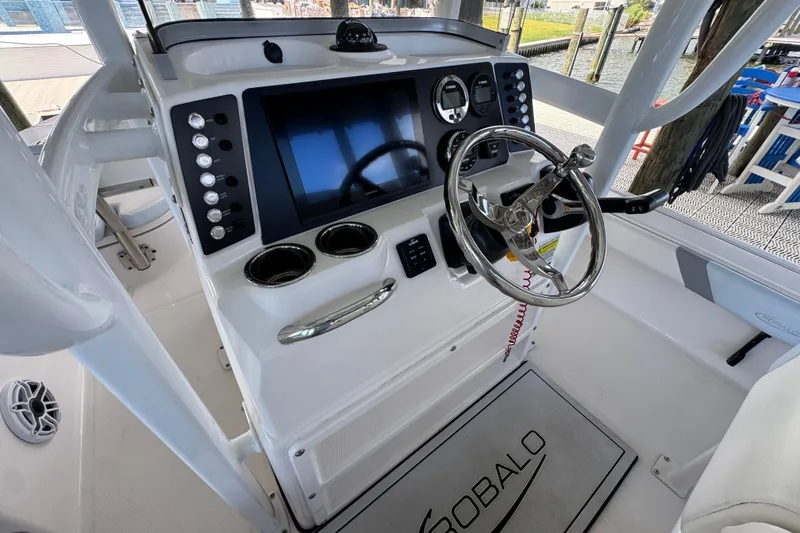 Slide: The Image of 2025 Robalo 226 Cayman boat dashboard with steering wheel and control panel. - 25