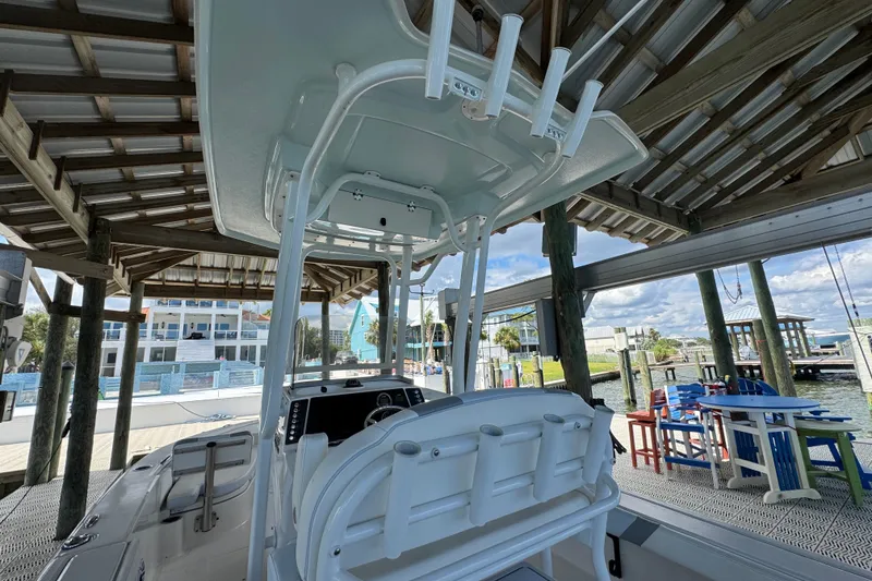 Slide: The Image of 2025 Robalo 226 Cayman boat docked under a wooden shelter, with waterfront view. - 31