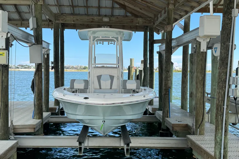 Slide: The Image of 2025 Robalo 226 Cayman boat docked under a wooden shelter by the water. - 3