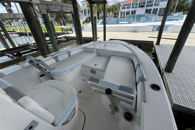 Slide: The Image of 2025 Robalo 226 Cayman boat interior at dock, featuring seating and storage compartments. - 13