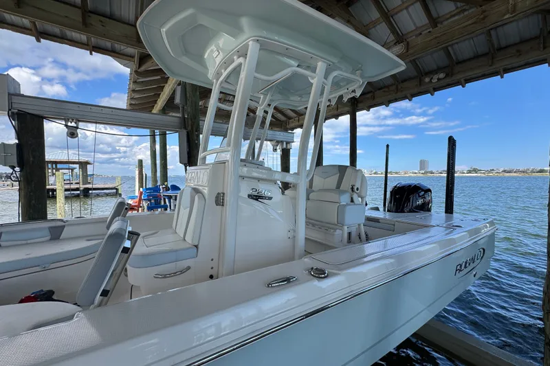 Slide: The Image of 2025 Robalo 226 Cayman boat docked under a wooden shelter by the water. - 6