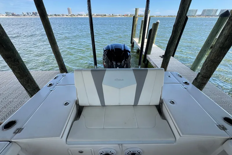 Slide: The Image of 2025 Robalo 226 Cayman boat docked, showcasing rear seating and engine view. - 33