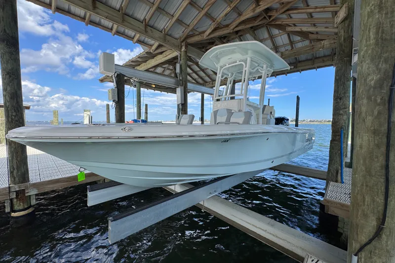 Slide: The Image of 2025 Robalo 226 Cayman boat docked under a wooden shelter on a sunny day. - 5