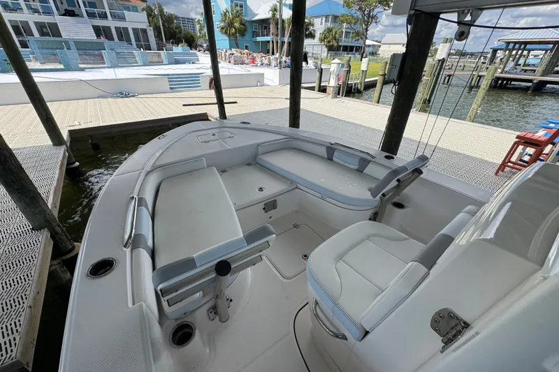 Slide: The Image of 2025 Robalo 226 Cayman boat interior at dock, featuring seating and storage areas. - 15
