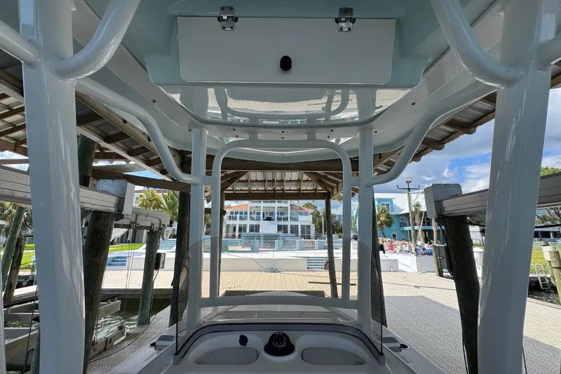 Slide: The Image of 2025 Robalo 226 Cayman boat docked under a wooden shelter, showcasing sleek design and modern features. - 27