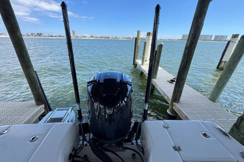 Slide: The Image of 2025 Robalo 226 Cayman boat docked, featuring a powerful outboard motor and scenic waterfront view. - 34