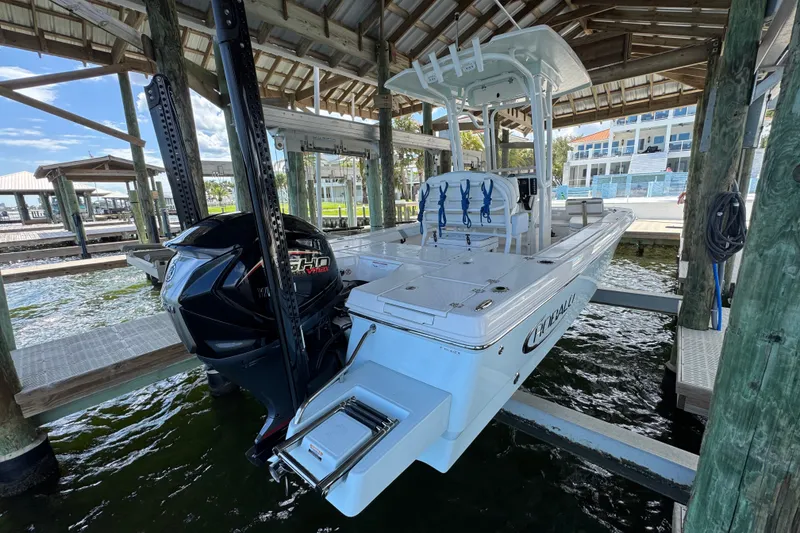 Slide: The Image of 2025 Robalo 226 Cayman boat docked under a wooden shelter. - 12