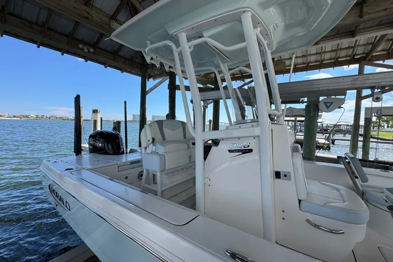 Slide: The Image of 2025 Robalo 226 Cayman boat docked under a wooden shelter by the water. - 10