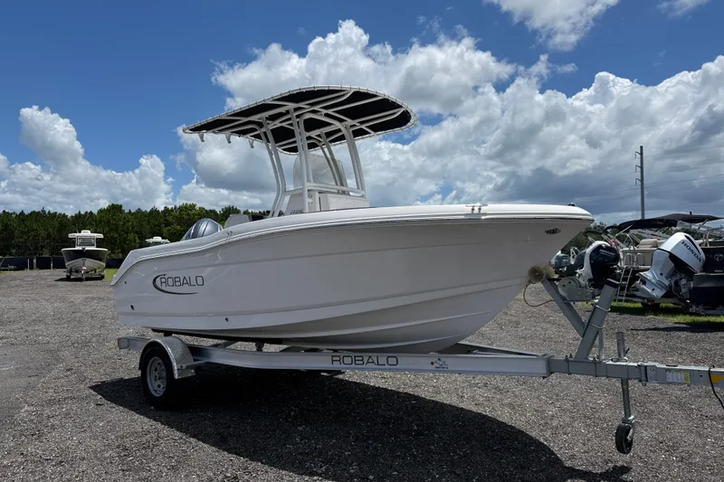 Slide: The Image of 2024 Robalo R180 Center Console boat on trailer under cloudy sky. - 6