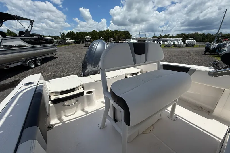 Slide: The Image of 2024 Robalo R180 Center Console boat interior with seating and storage, under a cloudy sky. - 10