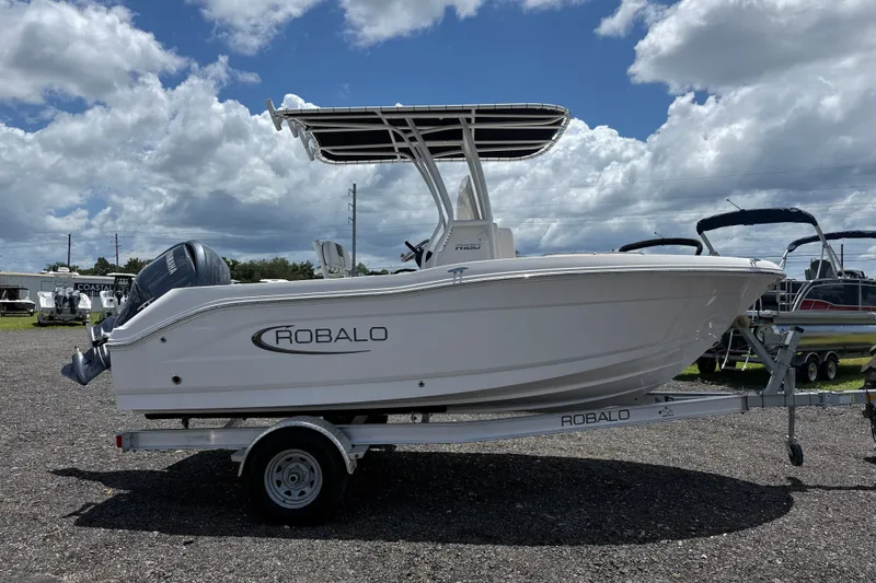 Slide: The Image of 2024 Robalo R180 Center Console boat on trailer under cloudy sky. - 5