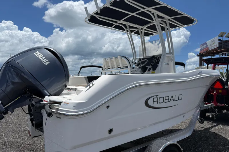 Slide: The Image of 2024 Robalo R180 Center Console boat with Yamaha engine, parked outdoors under cloudy sky. - 4