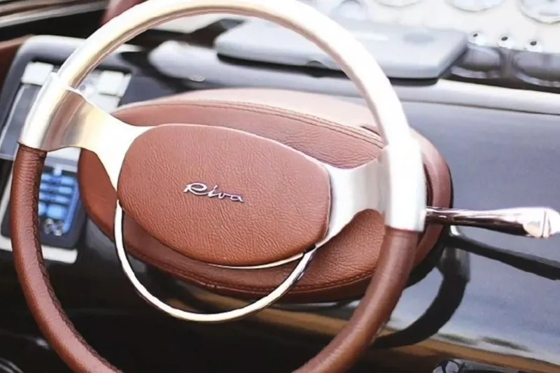 Slide: The Image of Steering wheel of a 2009 Riva 33' Aquariva boat, featuring elegant leather design. - 6