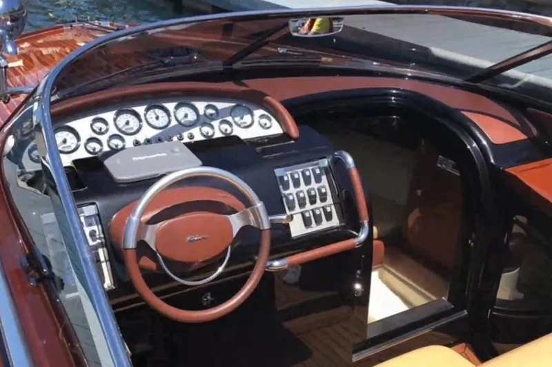 Slide: The Image of Interior view of a 2009 Riva 33' Aquariva boat dashboard with classic gauges and steering wheel. - 5