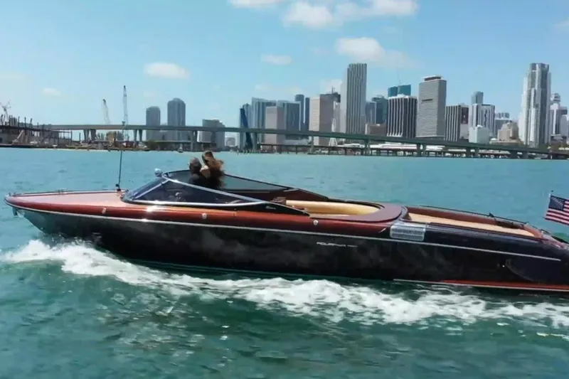 Slide: The Image of 2009 Riva 33' Aquariva cruising on water with city skyline in background. - 1