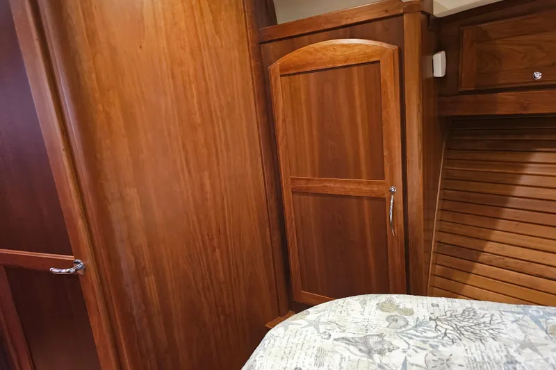 Slide: The Image of Interior of 2013 Sabre 48 Salon Express with wooden cabinetry and patterned bedding. - 47