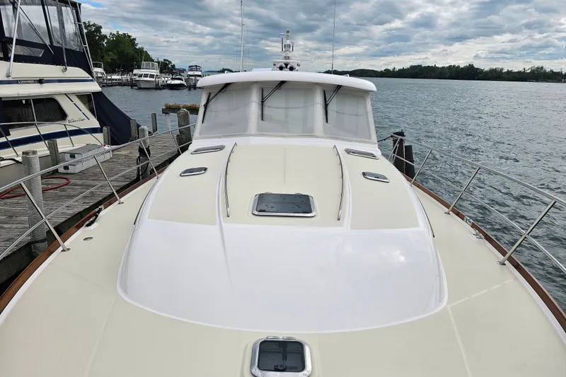 Slide: The Image of 2013 Sabre 48 Salon Express yacht docked by a scenic waterfront. - 2