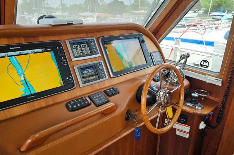 Slide: The Image of Cockpit of 2013 Sabre 48 Salon Express with navigation screens and steering wheel. - 17