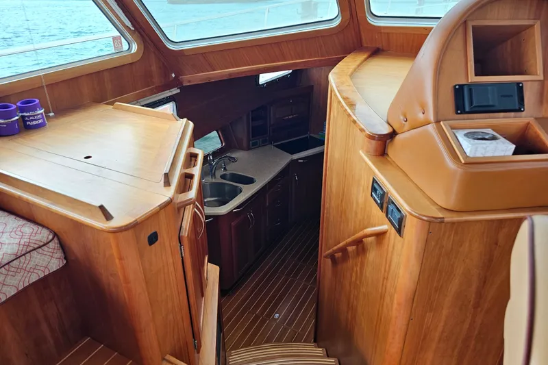 Slide: The Image of Interior of 2013 Sabre 48 Salon Express yacht, featuring wood finishes and a compact kitchen area. - 28