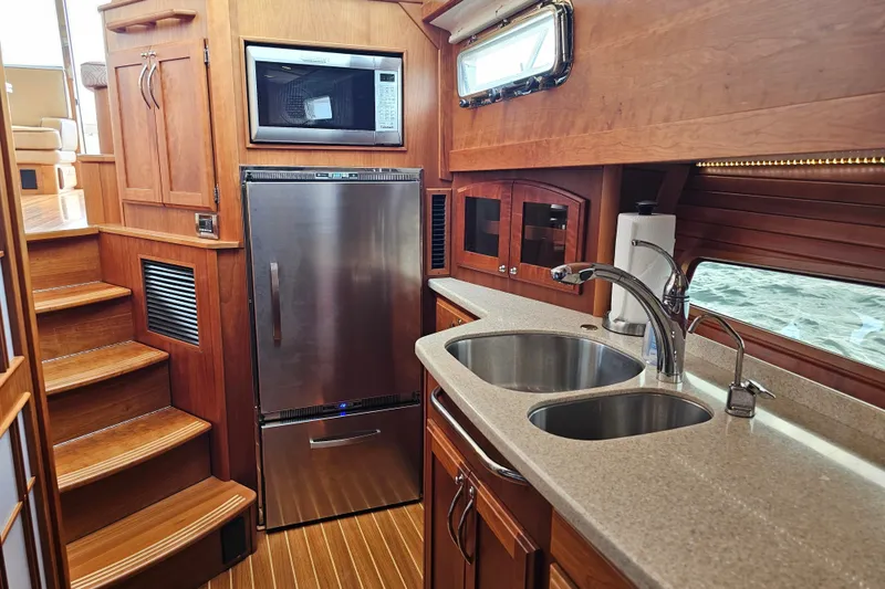 Slide: The Image of Interior of 2013 Sabre 48 Salon Express yacht kitchen with wood cabinetry and stainless steel appliances. - 34