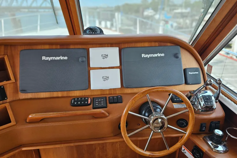 Slide: The Image of 2013 Sabre 48 Salon Express helm with Raymarine navigation equipment and wooden steering wheel. - 19