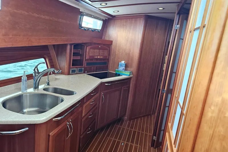 Slide: The Image of Luxurious 2013 Sabre 48 Salon Express yacht interior with elegant wood cabinetry and modern kitchen amenities. - 33