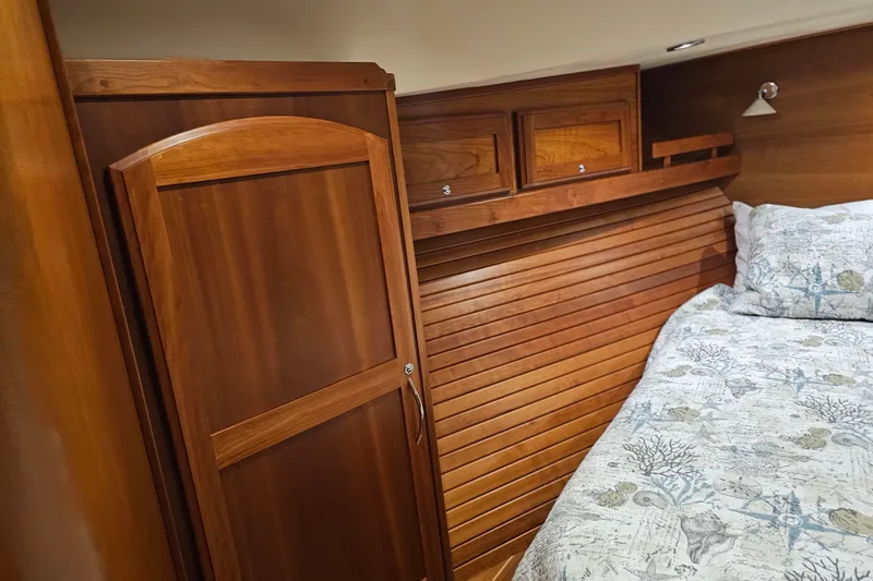 Slide: The Image of 2013 Sabre 48 Salon Express cabin interior with wooden cabinetry and patterned bedding. - 41