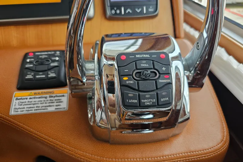 Slide: The Image of Control panel of a 2013 Sabre 48 Salon Express yacht, featuring throttle and navigation controls. - 23