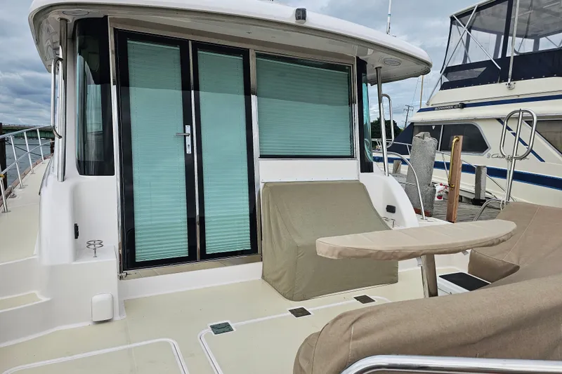 Slide: The Image of 2013 Sabre 48 Salon Express yacht with covered seating and glass doors at the dock. - 6