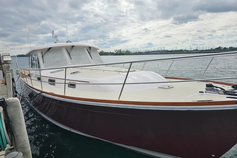 Slide: The Image of 2013 Sabre 48 Salon Express yacht docked by the water under cloudy skies. - 1